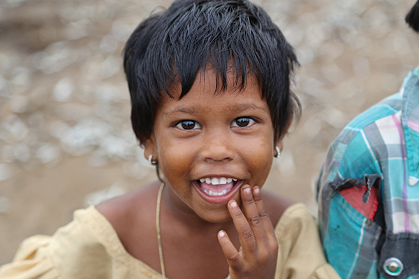 A little girl smiles at a dinner outreach in India hosted by Mission to Children.